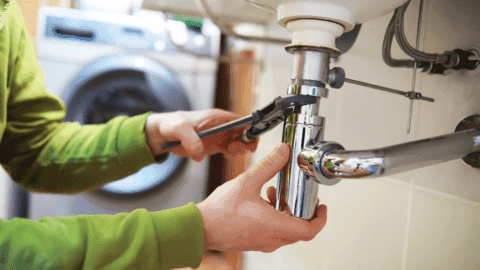 Sanitärarbeit unter einem Waschbecken